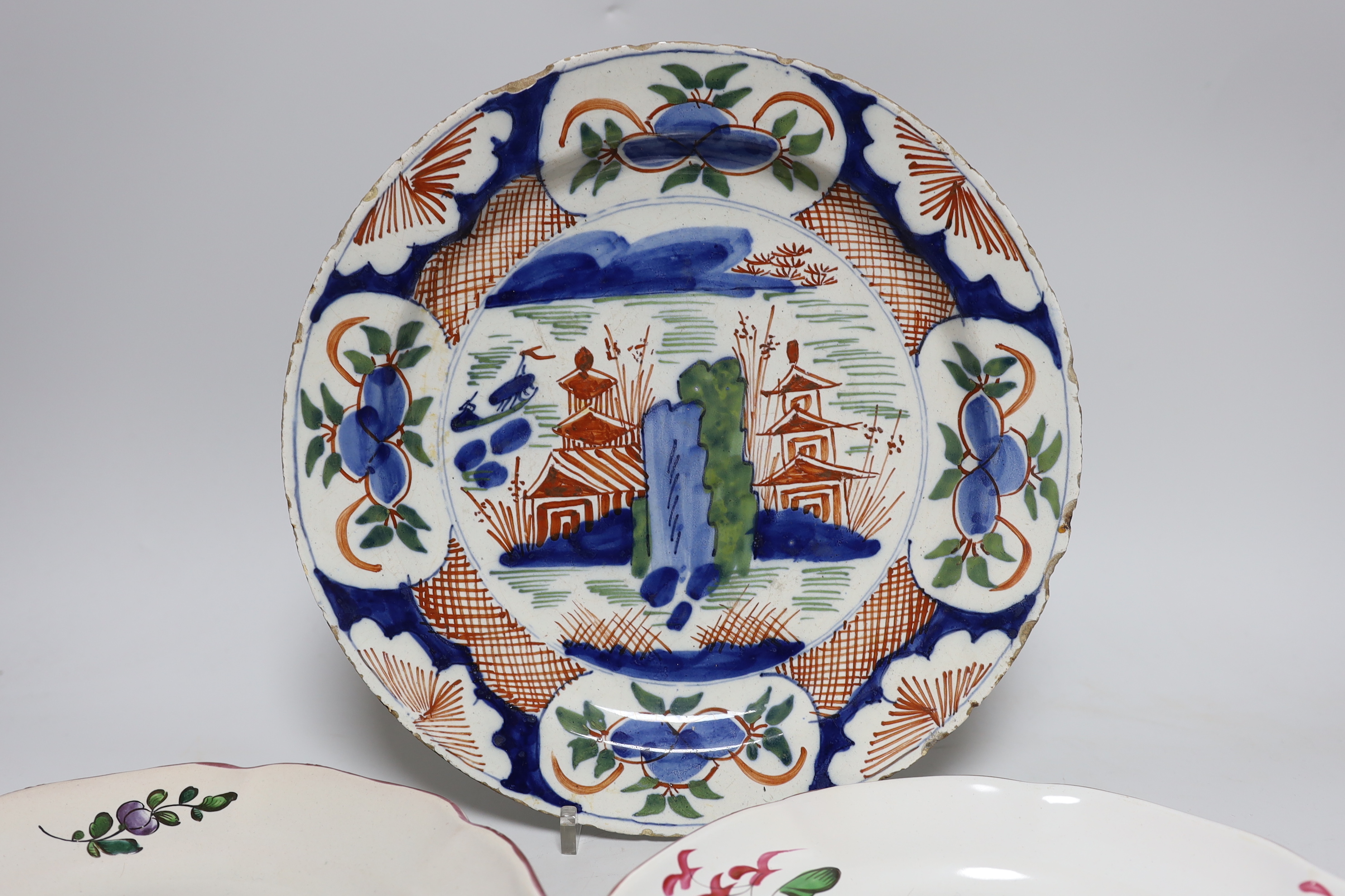 An 18th century Delft plate and three 19th century faience plates, largest 26cm diameter (4)